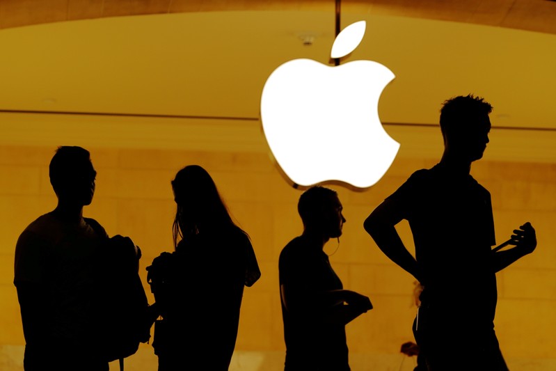 FILE PHOTO: Customers walk past an Apple logo inside of an Apple store at Grand Central Station in New York