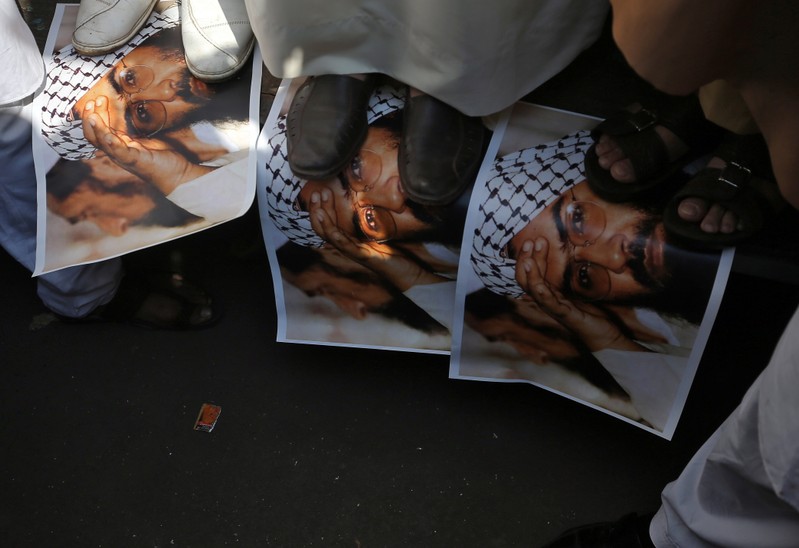 Demonstrators step on the posters of Maulana Masood Azhar, head of Pakistan-based militant group Jaish-e-Mohammad, during a protest in Mumbai