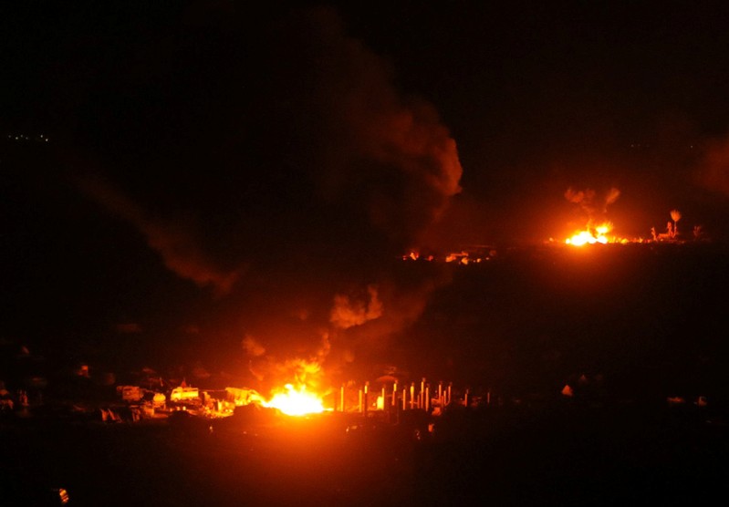 Fire and plumes of smoke are seen during fighting in the Islamic State's final enclave, in the village of Baghouz, Deir Al Zor province