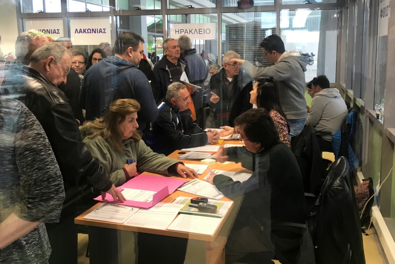 People line up to register their assets at the land registry offices in Athens