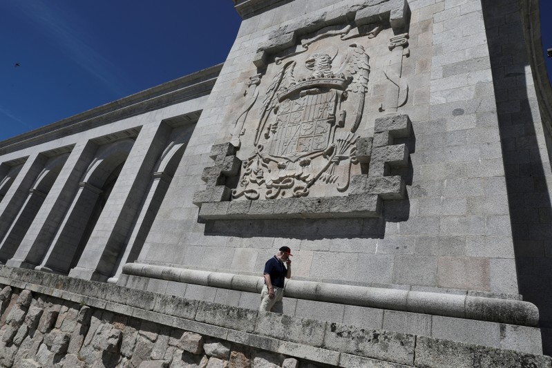 FILE PHOTO: A man walks underneath a huge Franco-era coat of arms at the Valle de los Caidos (Valley of the Fallen) monument where over 30,000 fighters from both sides of Spain's civil war are buried, in San Lorenzo de El Escorial, outside Madrid
