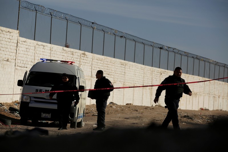 Forensic technicians work at a crime scene where a mutilated body was left by unknown assailants in Ciudad Juarez