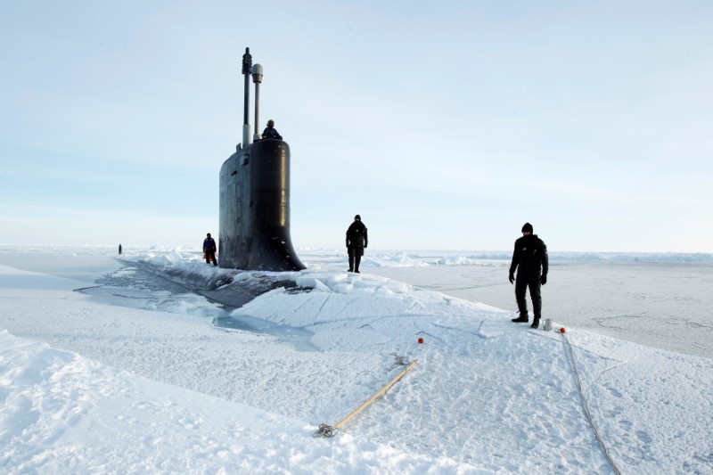 FILE PHOTO: U.S. Navy safety swimmers stand on the deck of the Virginia class submarine USS New Hampshire after it surfaced in the Arctic Ocean north of Prudhoe Bay