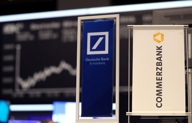 FILE PHOTO: Banners of Deutsche Bank and Commerzbank are pictured in front of the German share price index, DAX in Frankfurt