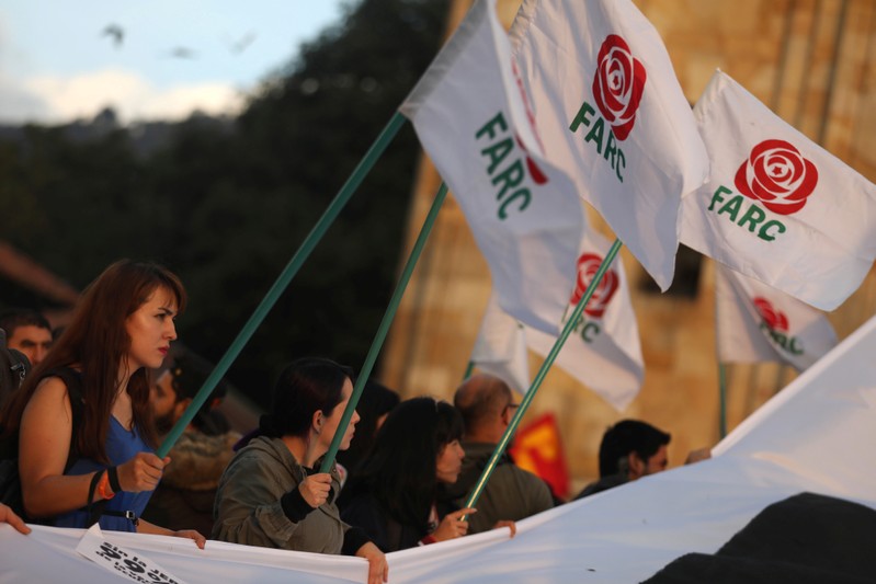 A woman holds a flag of the Revolutionary Alternative Force of the Common (FARC) political party during a protest in support of the Special Jurisdiction for Peace (JEP) in Bogota