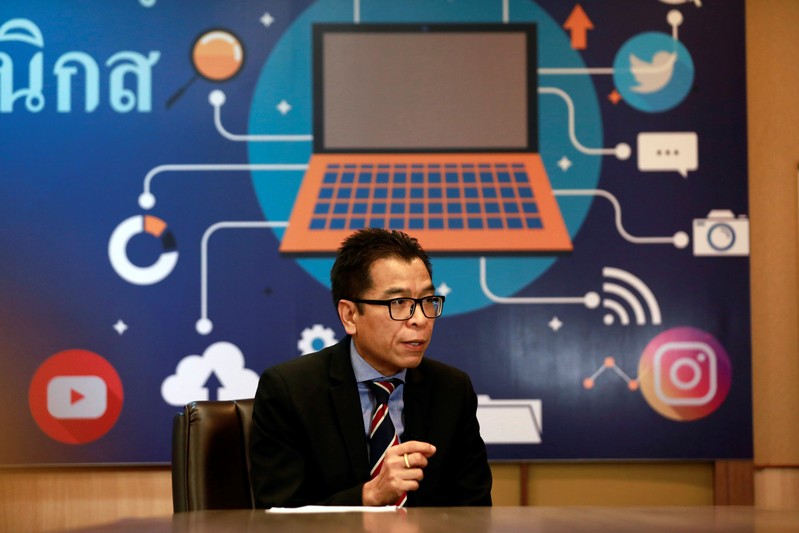 Sawang Boonmee, deputy secretary-general of Election Commission talks as he works in a social media war room in Bangkok
