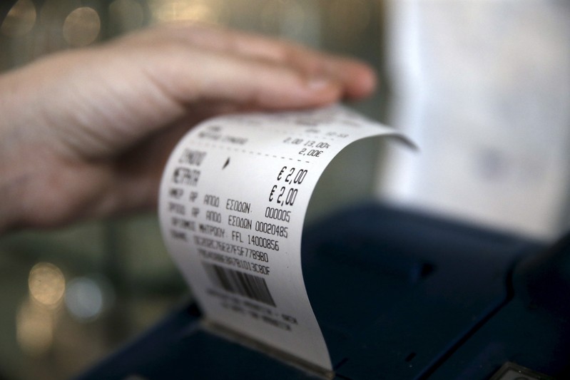 A waitress issues a receipt at a cafe in Athens