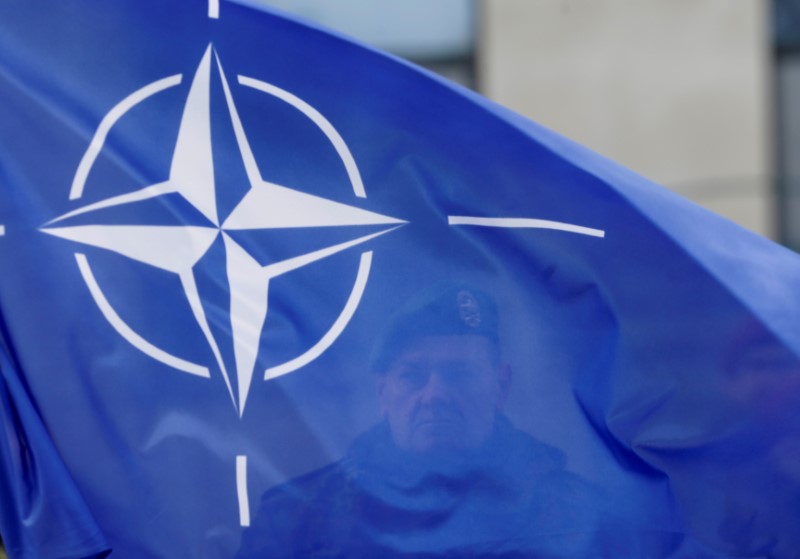 A German soldier holds NATO flag during a ceremony to welcome the German battalion being deployed to Lithuania as part of NATO deterrence measures against Russia in Rukla