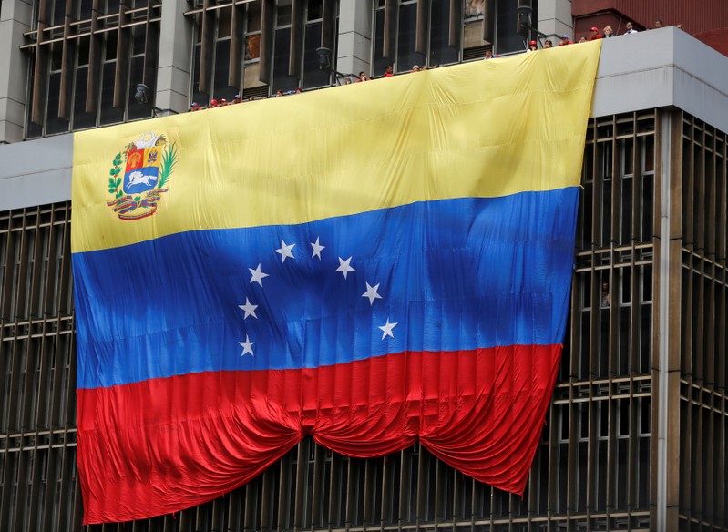 FILE PHOTO: A Venezuelan flag hangs from a building near the national election board as acting President Maduro registered as a candidate for president in the April 14 election in Caracas
