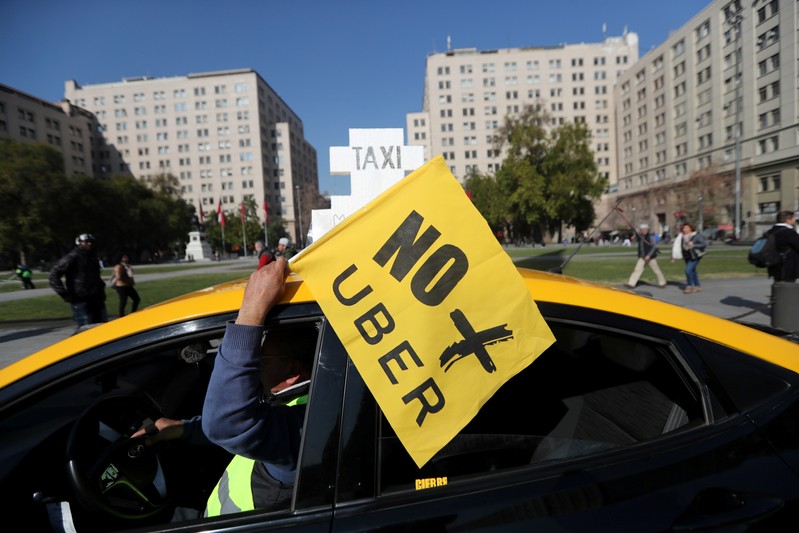 FILE PHOTO: A taxi driver holds a flag reading
