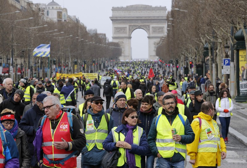 FILE PHOTO: Protesters wearing yellow vests walk down the Champs Elysees during a demonstration by the