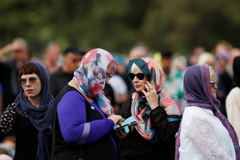 Women wearing headscarves as tribute to the victims of the mosque attacks are seen before Friday prayers at Hagley Park outside Al-Noor mosque in Christchurch