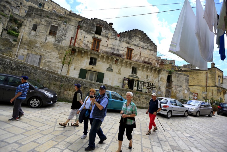 FILE PHOTO: Tourists walk on a street in Matera, southern Italy