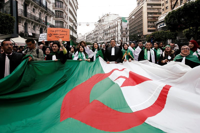 FILE PHOTO: Lawyers carry a national flag as they march during a protest to demand the immediate resignation of President Abdelaziz Bouteflika, in Algiers