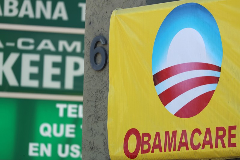 FILE PHOTO - A sign on an insurance store advertises Obamacare in San Ysidro