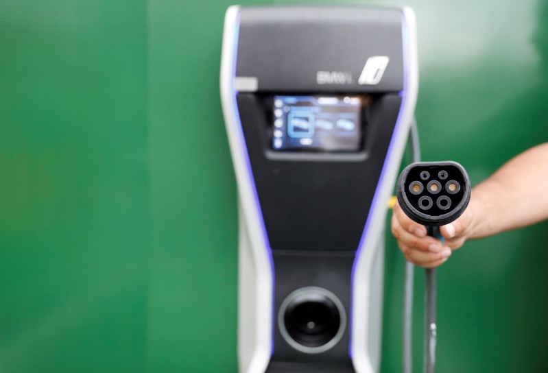 FILE PHOTO: Man holds an electric car charger in a car park at a McDonald's restaurant in Sao Paulo