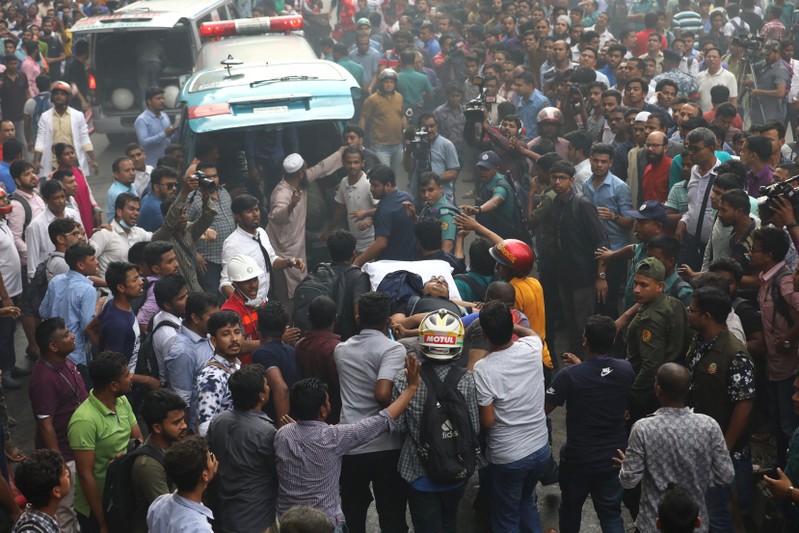 A rescued person is taken to the ambulance as fire broke out at a multi-storey commercial building in Dhaka