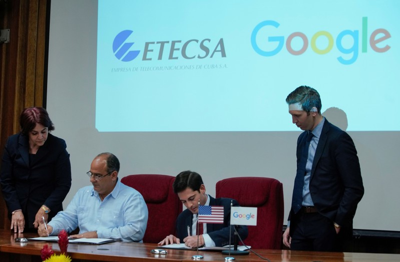 Google's Head of Strategy and Operations in Cuba, Brett Perlmutter, and Vice President of Investment of Etecsa, Luis Adolfo Reyes, sign documents in Havana
