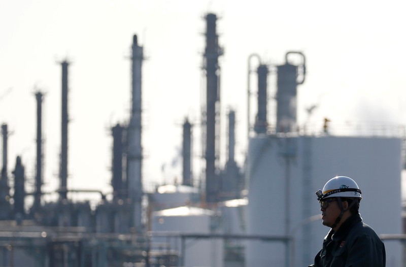FILE PHOTO: A worker walks near a factory at the Keihin industrial zone in Kawasaki