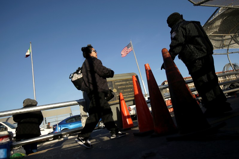 A commuter walks by a U.S. Customs and Border Protection (CBP) agent as she crosses into El Paso, Texas, at Paso del Norte international border crossing bridge, in Ciudad Juarez
