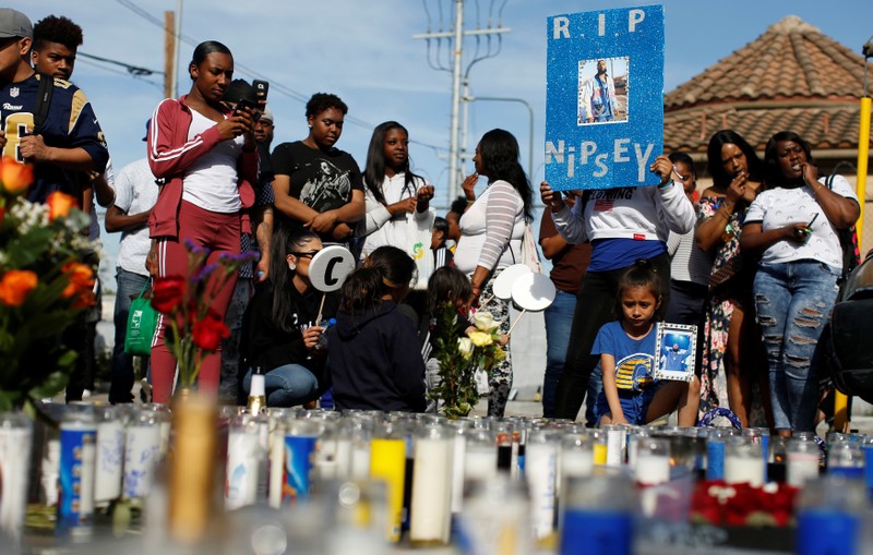 People gather around a makeshift memorial for Grammy-nominated rapper Nipsey Hussle who was shot and killed outside his clothing store in Los Angeles