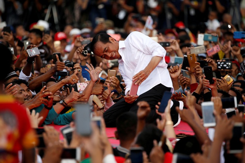 FILE PHOTO: Indonesia's presidential candidate for the upcoming general election Joko Widodo takes pictures with his supporters during his first campaign rally at a stadium in Serang
