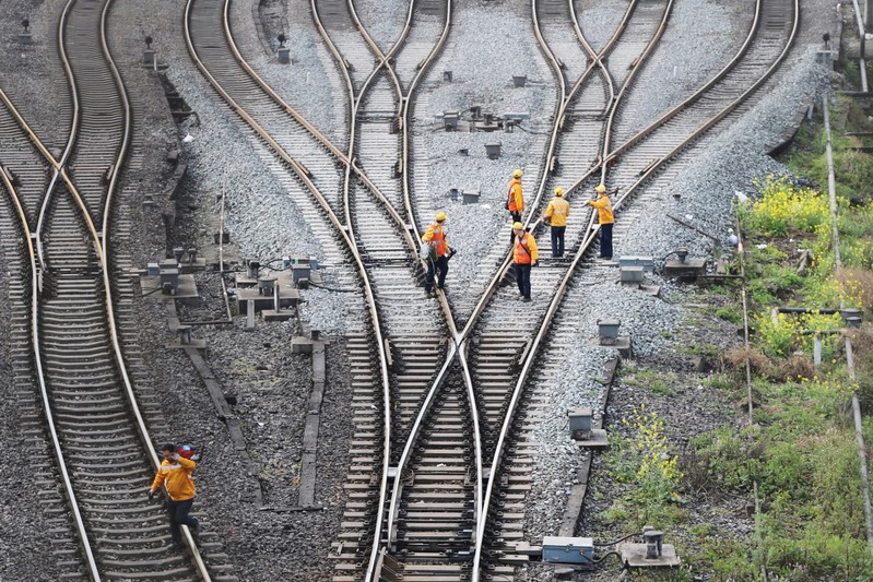 FILE PHOTO: Workers inspect railway tracks, which serve as a part of the Belt and Road freight rail route linking Chongqing to Duisburg, at the Dazhou railway station