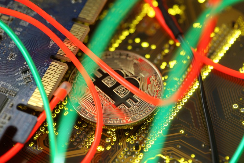 FILE PHOTO: Representation of the Bitcoin virtual currency standing on a PC motherboard