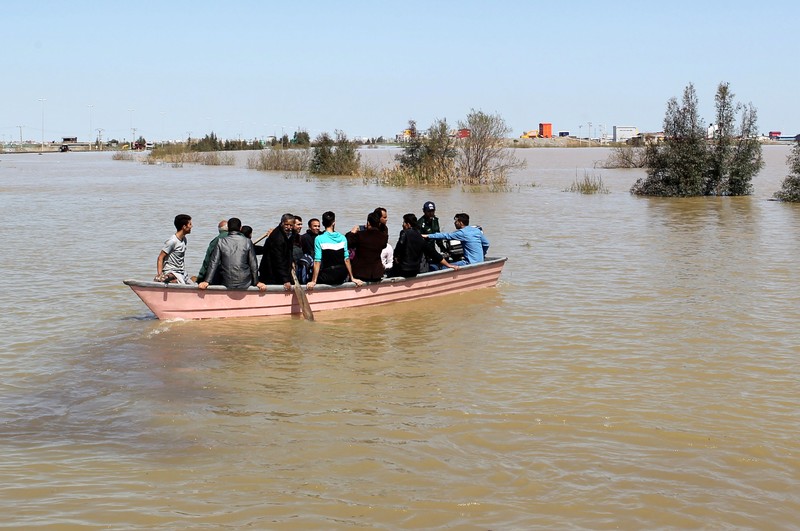 FILE PHOTO: People are seen on a boat after a flooding in Golestan province