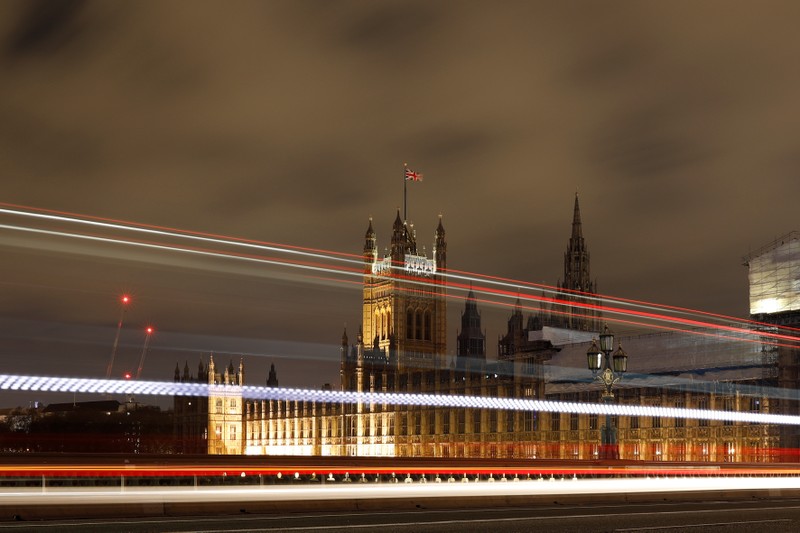 Cars drive over Westminster Bridge as the Houses of Parliament is seen in the background, in Westminster, central London