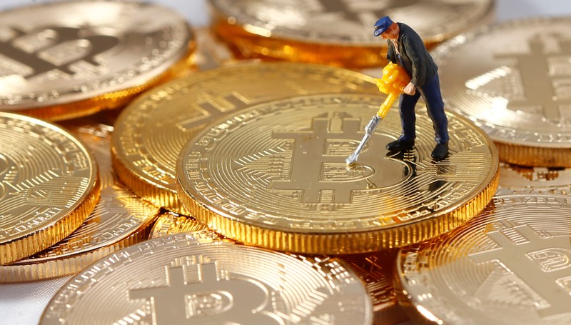 A small toy figure is seen on representations of the Bitcoin virtual currency in this illustration picture