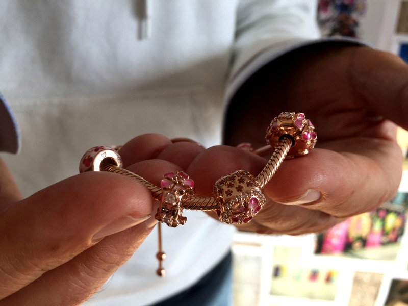 A Pandora employee shows a piece from the new jewelry collection Peach Blossom in the company's headquarters in Copenhagen