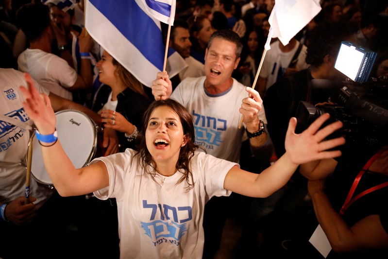Supporters of Benny Gantz's Blue and White party react to exit polls in Israel's parliamentary election at the party headquarters in Tel Aviv, Israel