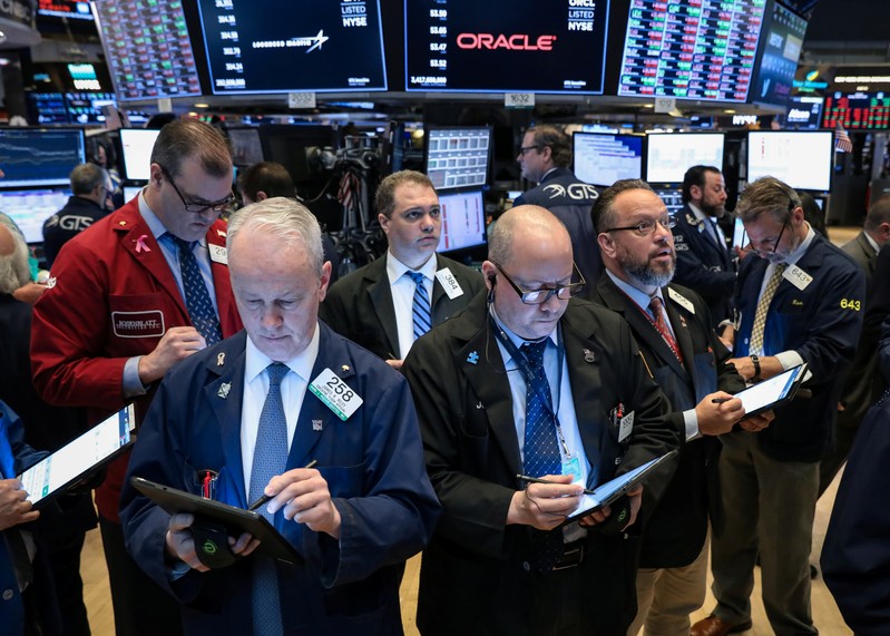 FILE PHOTO: Traders work on the floor at the NYSE in New York