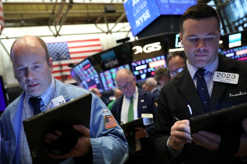 FILE PHOTO: Traders work on the floor at the NYSE in New York