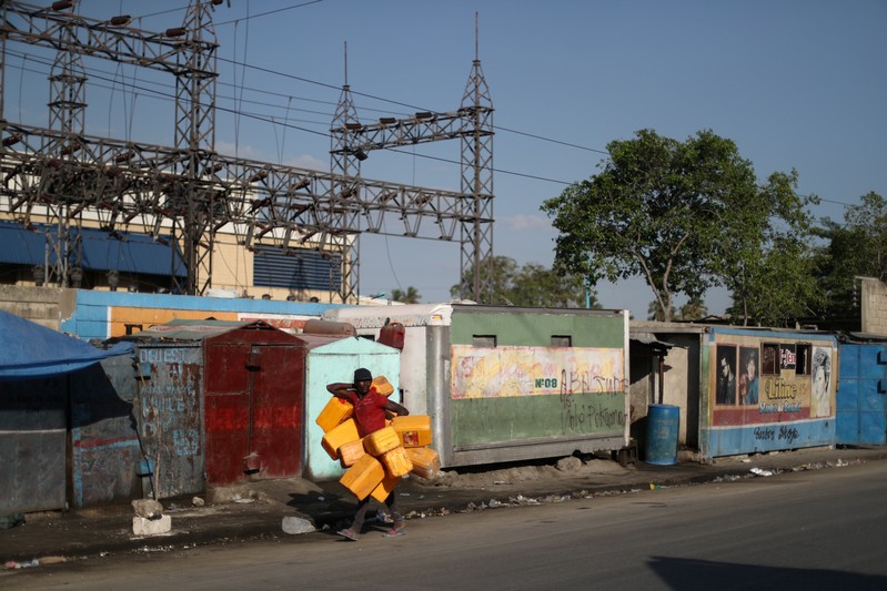 A man carries containers used to filled them with fuel that is sold on the black market in Port-au-Prince