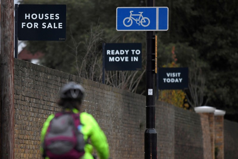 FILE PHOTO: Property sale signs are seen outside of a group of newly built houses in west London