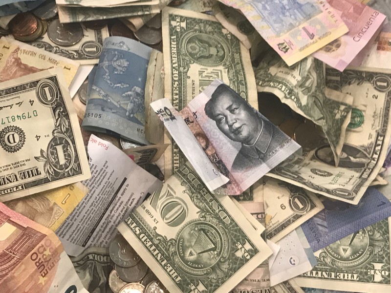 FILE PHOTO: U.S. dollars and other world currencies lie in a charity receptacle at Pearson international airport in Toronto
