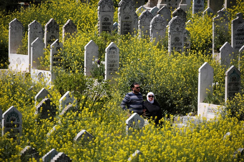 People visit a cemetery in al-Shaar neighborhood of Aleppo