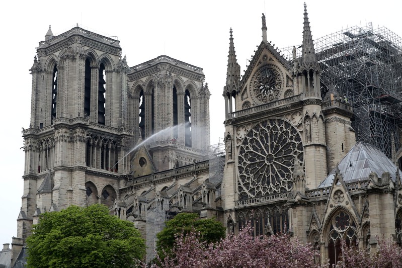 Firefighters work at Notre-Dame Cathedral after a massive fire devastated large parts of the gothic gem in Paris