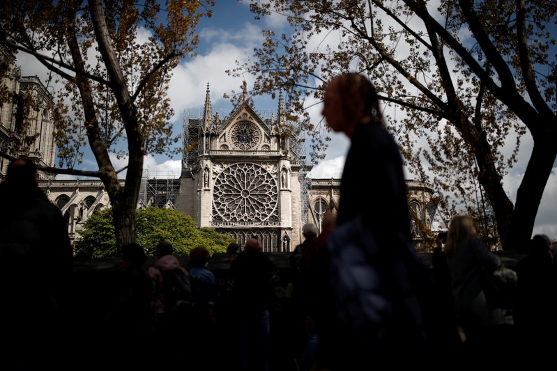 People look at Notre-Dame Cathedral two days after a massive fire devastated large parts of the gothic structure in Paris