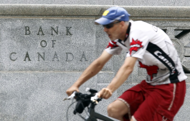 A cyclist rides past the Bank of Canada building in Ottawa