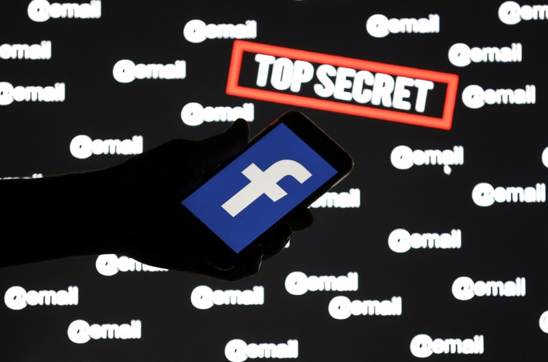 FILE PHOTO: A person holds a smartphone with the Facebook logo in front of displayed