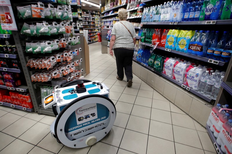 A woman does her shopping at a store using an autonomous robot, shaped and inspired by Star Wars R2D2, in a test for the delivery of groceries by Franprix supermarket chain in the 13th district of Paris