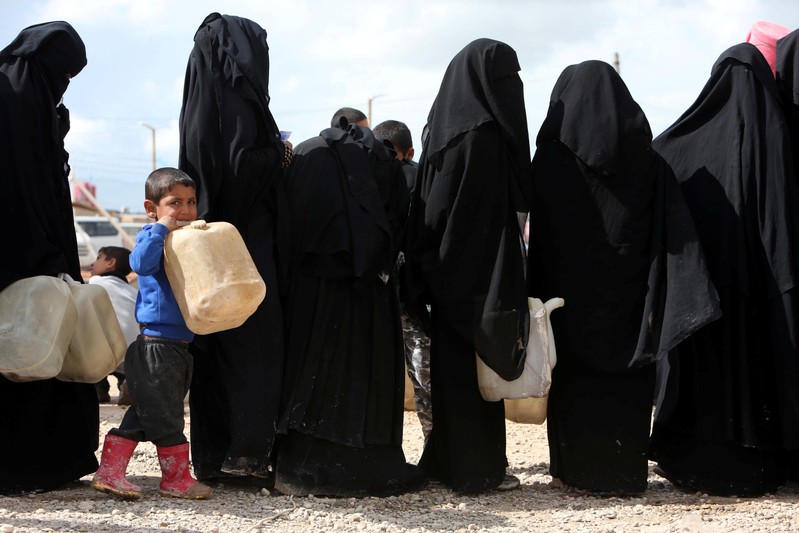 Women stand in line to get fuel at al-Hol displacement camp in Hasaka governorate
