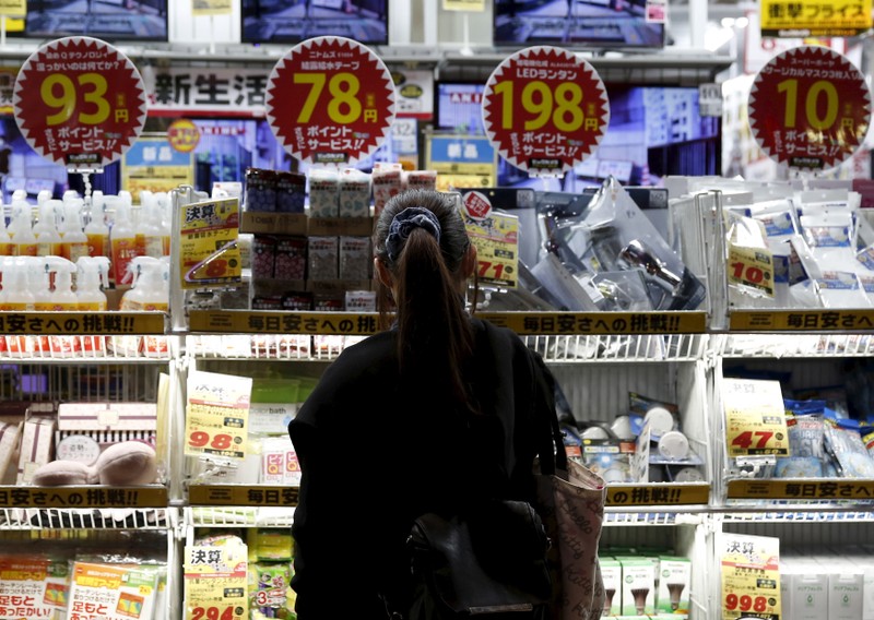A woman looks at items outside an outlet store at a shopping district in Tokyo