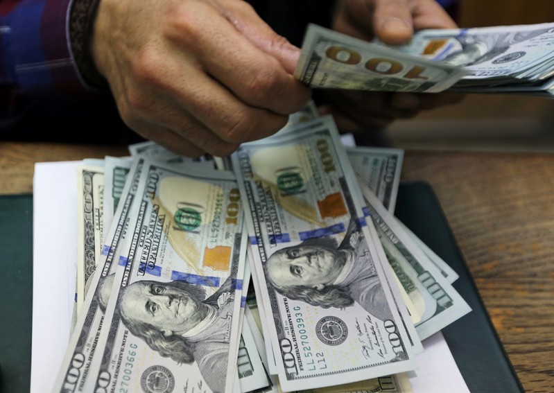 An employee counts U.S dollar bills at a money exchange office in central Cairo