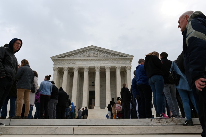 FILE PHOTO: People wait in line outside the U.S. Supreme Court to hear the orders being issued, in Washington