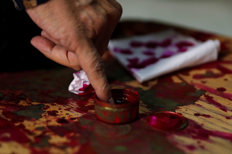 Man has his finger stained with ink during the second day of the referendum on draft constitutional amendments, at a polling station in Cairo