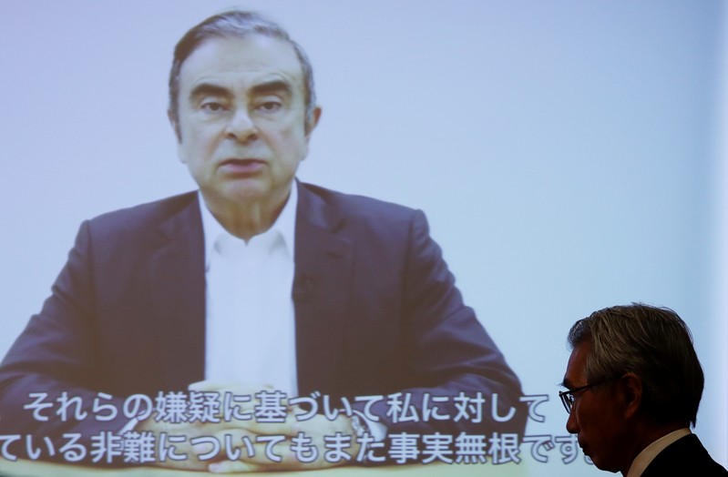 FILE PHOTO: Junichiro Hironaka, chief lawyer of the former Nissan Motor chairman Carlos Ghosn, walks in front of a screen showing Ghosn's video statement during a news conference at Foreign Correspondents' Club of Japan in Tokyo